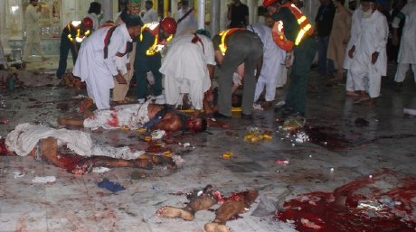 LAHORE,PAKISTAN - JULY 1: (EDITORS NOTE: GRAPHIC CONTENT) Worshippers and rescue workers carry victims from the Data Ganj Baksh shrine on July 1, 2010 in Lahore, Pakistan. At least 35 people have been killed and 175 people injured after three suicide bomb blasts hit the Data Ganj Baksh shrine . (Photo by Nadeem Ejaz/Getty Images)