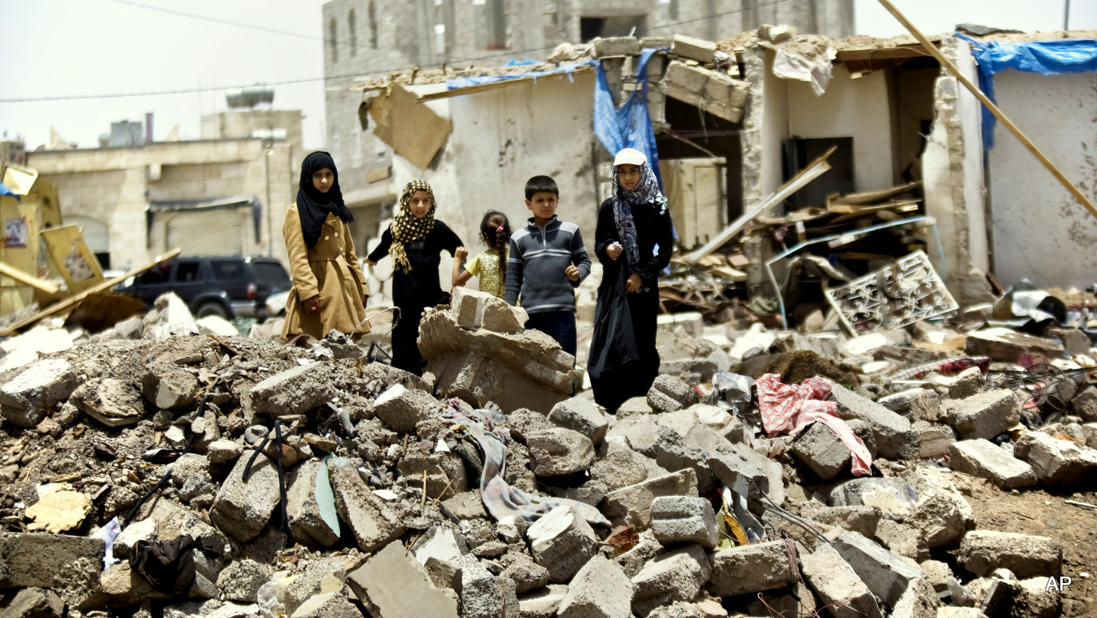 Varios niños juegan junto a una casa destruida por la aviación saudí en Yemen