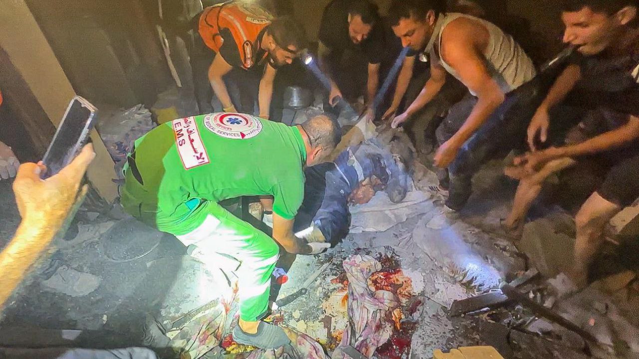 Rescatistas palestinos recogen víctimas en el campo de Al-Bureiy