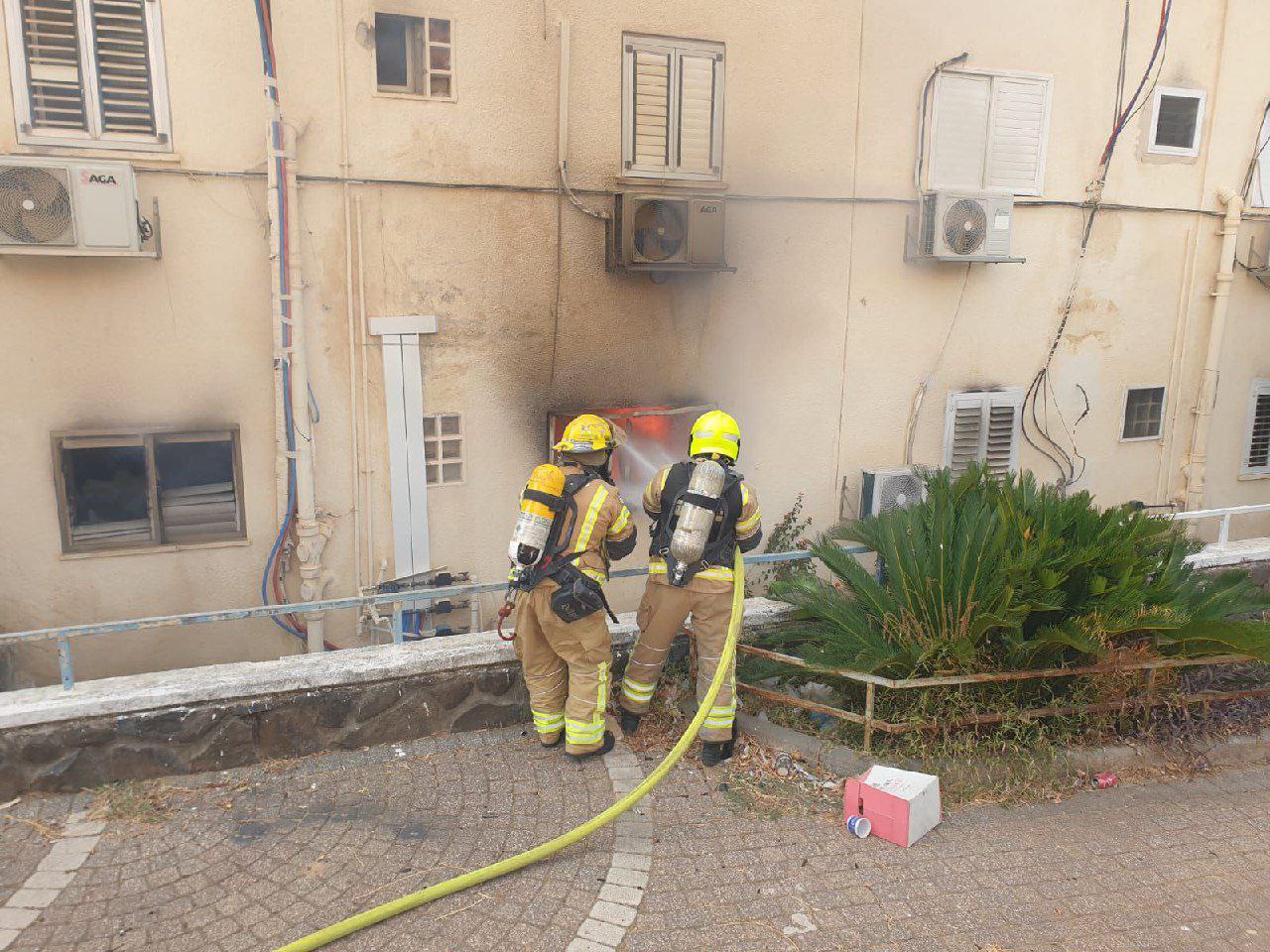 Bomberos israelíes junto a un edificio dañado en Kiryat Shmona