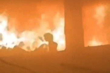 Una niña intenta escapar tras ser rodeada por fuego en un ataque aéreo israelí contra la escuela Fahmi al-Jarjawi, que alberga a personas desplazadas en el barrio de al-Daraj de la ciudad de Gaza