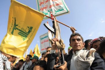Un yemení sostiene la bandera de Hezbolá